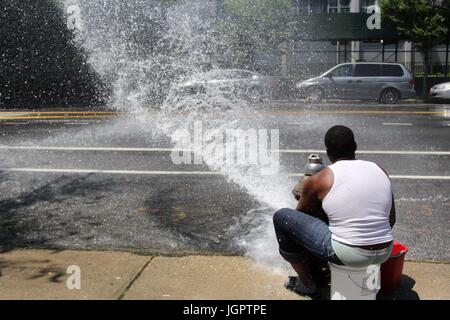 New York, USA. 09 juillet, 2017. Le Bronx, New York, USA - 9 juillet, 2017 - Les résidents de l'Foxhurst article du Bronx, New York, et inciter les automobilistes à s'arrêter pour un lavage de voiture bon marché. Par l'ouverture d'un New York Fire Department (NYFD) borne fontaine et la direction de l'eau avec leurs mains mélangé avec du détergent, le mélange savonneux couvre les véhicules qui passent. Les jeunes alors espérons que les automobilistes s'arrêtent pour un lavage rapide et économique trottoir. Credit : Ronald G. Lopez /DigiPixsAgain.us/Alamy Live News Banque D'Images