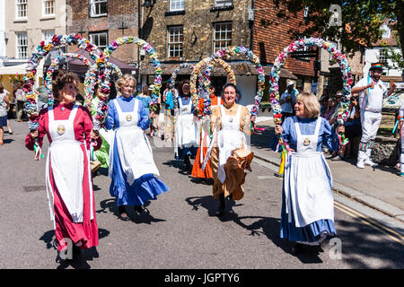 Danseurs folkloriques traditionnels anglais, les femmes de la Noeuds de May Morris, danser dans la rue maintenant demi-cercle des guirlandes de fleurs sur la tête. Banque D'Images