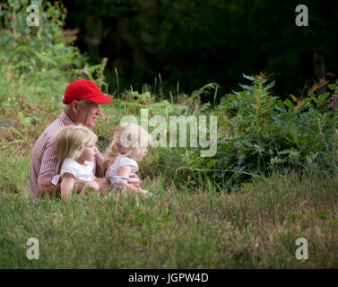 Grindleford Derbyshire, Royaume-Uni. 09 juillet 2017. A 78 ans, grand-père s'occupe de ses deux petits-enfants jumeaux, Minnie et Tillie, âgée de trois ans, à Padley Chapelle, où des centaines de catholiques du diocèse de Hallam et Nottingham assister à la messe à l'Assemblée Padley pèlerinage . Le pèlerinage a débuté en 1898 à l'honneur deux prêtres catholiques, Nicholas Garlick et Robert Ludlum, qui, après avoir été ordonnés prêtres sur le continent, de haute trahison commis par son retour en Angleterre. Ils ont été arrêtés à Padley Manor et exécuté à Derby en 1588. Crédit : John Fryer/Alamy Live News Banque D'Images