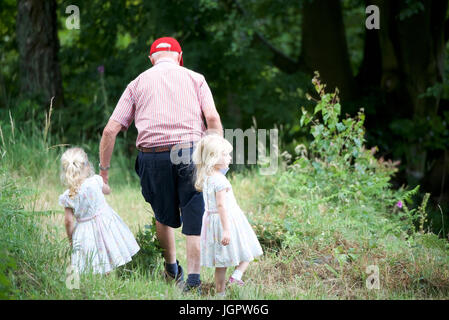 Grindleford Derbyshire, Royaume-Uni. 09 juillet 2017. A 78 ans, grand-père s'occupe de ses deux petits-enfants jumeaux, Minnie et Tillie, âgée de trois ans, à Padley Chapelle, où des centaines de catholiques du diocèse de Hallam et Nottingham assister à la messe à l'Assemblée Padley pèlerinage . Le pèlerinage a débuté en 1898 à l'honneur deux prêtres catholiques, Nicholas Garlick et Robert Ludlum, qui, après avoir été ordonnés prêtres sur le continent, de haute trahison commis par son retour en Angleterre. Crédit : John Fryer/Alamy Live News Banque D'Images
