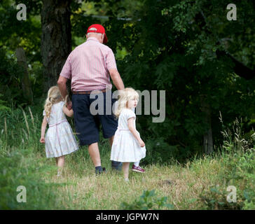 Grindleford Derbyshire, Royaume-Uni. 09 juillet 2017. A 78 ans, grand-père s'occupe de ses deux petits-enfants jumeaux, Minnie et Tillie, âgée de trois ans, à Padley Chapelle, où des centaines de catholiques du diocèse de Hallam et Nottingham assister à la messe à l'Assemblée Padley pèlerinage . Le pèlerinage a débuté en 1898 à l'honneur deux prêtres catholiques, Nicholas Garlick et Robert Ludlum, qui, après avoir été ordonnés prêtres sur le continent, de haute trahison commis par son retour en Angleterre. Crédit : John Fryer/Alamy Live News Banque D'Images
