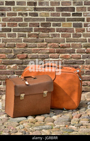 Valises vintage d'un voyageur à l'avant d'un mur de briques Banque D'Images