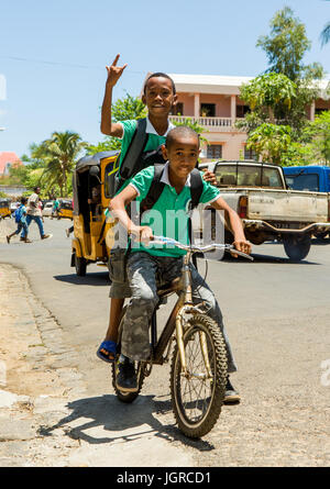 MADAGASCAR, Diego Suarez - 3 décembre 2014 : deux étudiants de l'école rendez-vous en vélo après l'école à la maison. Madagascar, Diego Suarez. Le 3 septembre, 2014 Banque D'Images