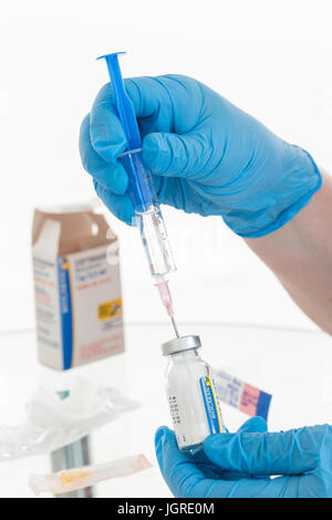 Vaccin contre l'infirmière mains tenant la seringue et le flacon on white Banque D'Images