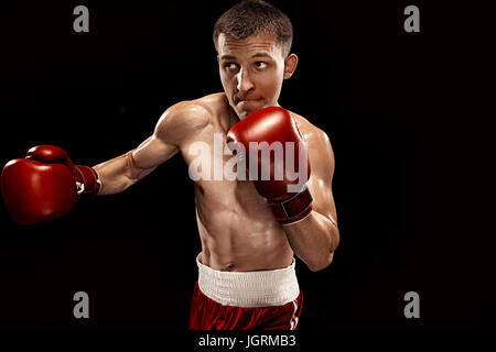 Male boxer boxing avec éclairage edgy spectaculaire dans un studio sombre Banque D'Images