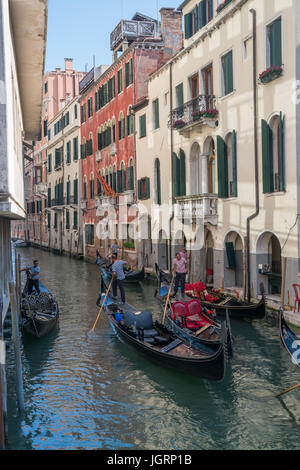 Venise, Italie - 1 juillet 2016 : Gondoliers naviguer à travers un canal gondoles à Venise, Italie. Banque D'Images