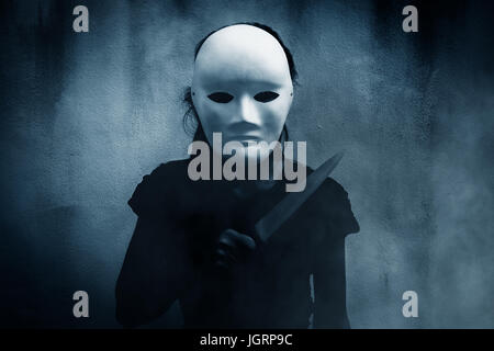 Mystérieuse femme en noir portant un masque blanc avec fond effrayant,couteau pour couverture de livre Banque D'Images