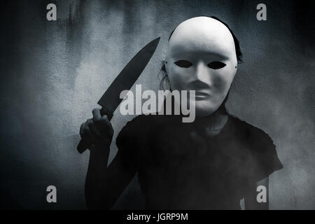 Mystérieuse femme en noir portant un masque blanc avec fond effrayant,couteau pour couverture de livre Banque D'Images