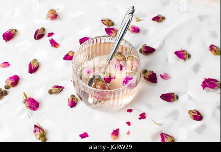 Dans une tasse de thé rose sur tissu blanc Banque D'Images