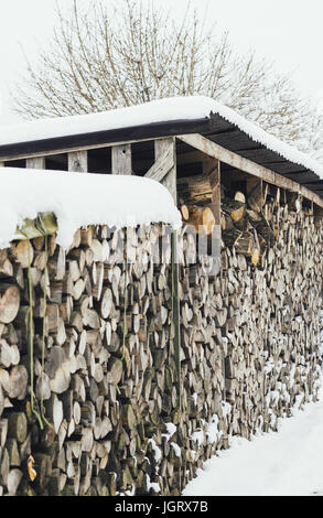 Bois de chauffage à l'extérieur couverts en hiver avec la neige. Banque D'Images