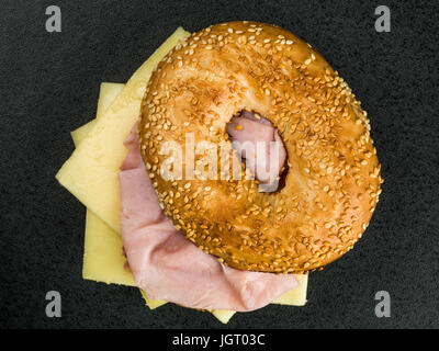 Jambon et fromage bagel grillé sur un fond noir Banque D'Images