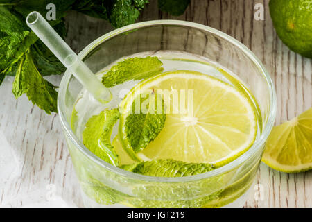 Mojito cocktail avec de la chaux, de la menthe et de la glace sur fond de bois blanc. Banque D'Images