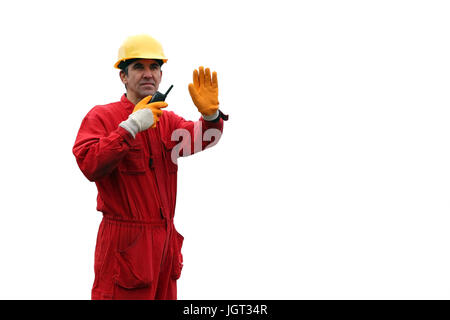 Un portrait d'un travailleur en salopette rouge et jaune, casque avec talkie-walkie. Banque D'Images