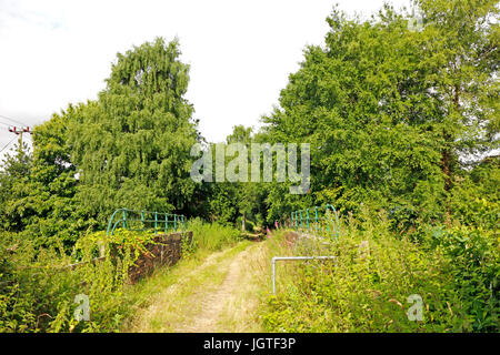 Les tisserands way sentier traversant un ancien pont ferroviaire par la gare désaffectée à felmingham, Norfolk, Angleterre, Royaume-Uni. Banque D'Images