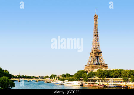 La Tour Eiffel à Paris, France, vu depuis le Pont de Bir-Hakeim au coucher du soleil avec la seine et les navettes touristiques au premier plan. Banque D'Images