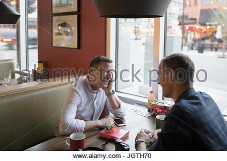 Male gay couple relaxing at diner booth
