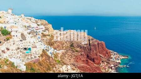 Croisés vue panoramique d'Oia, ville aux maisons blanches, moulins et petit port de jour d'été ensoleillé, Santorin ou Thira, Grèce Banque D'Images