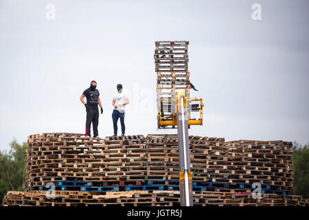 Des hommes masqués, continuer à construire un feu à Inverary Terrains de jeu en Belfast. La police en Irlande du Nord ont mis en garde leurs ressources pouvait être étendue dans un contexte de craintes de tensions autour de l'incendie de onzième Nuit de joie. Banque D'Images