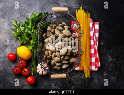 Les aliments crus Ingrédients pour la cuisson des spaghettis alle vongole sur fond sombre Banque D'Images