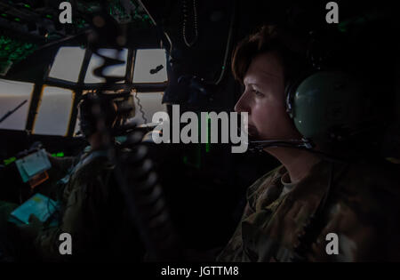 Un mécanicien de bord, affecté à la 746e Escadron de transport aérien expéditionnaire, communique avec les pilotes plus de casque sur un C-130H Hercules lors d'un vol à un endroit tenu secret, dans l'Asie du Sud-Ouest, le 23 juin 2017. C-130 ont le premier avion pour le transport de marchandises et de troupes pour les zones hostiles et austère d'aviation. (U.S. Photo de l'Armée de l'air par le sergent. Trevor T. McBride) Banque D'Images