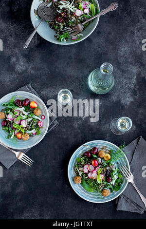 Salade de riz sauvage cerise Vinaigrette avec Hibiscus servi avec du vin blanc. Photographié sur un fond gris/noir. Banque D'Images