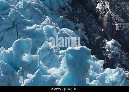 La glace de glacier bleu pousse contre l'effritement black rock Banque D'Images