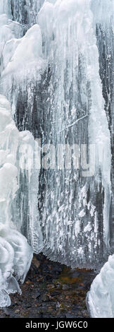 L'année de l'eau de source s'écoule dans les draperies de glace dans des températures inférieures à zéro. Banque D'Images