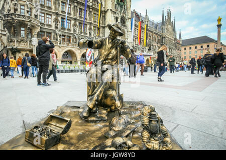 MUNICH, ALLEMAGNE - le 9 mai 2017 : un artiste de rue déguisés en une sculpture fontaine avec des personnes dans le contexte de visites Marienplatz à Munich Banque D'Images