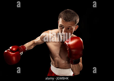 Male boxer boxing avec éclairage edgy spectaculaire dans un studio sombre Banque D'Images