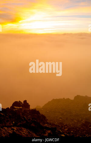 Lever de soleil derrière les nuages sur le sommet de Haleakala sur Maui, Hawaii, USA. Banque D'Images