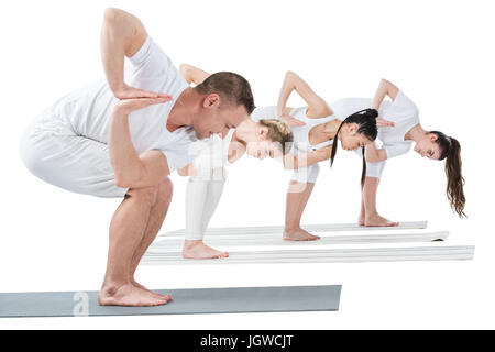 Les jeunes femmes avec la pratique de formateur tournait yoga sur chaise poser sur des nattes Banque D'Images