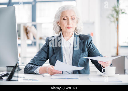 Senior businesswoman typing sur le lieu de travail Banque D'Images