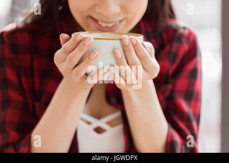 Vue rapprochée de la femme de boire du café à partir de la grande tasse Banque D'Images