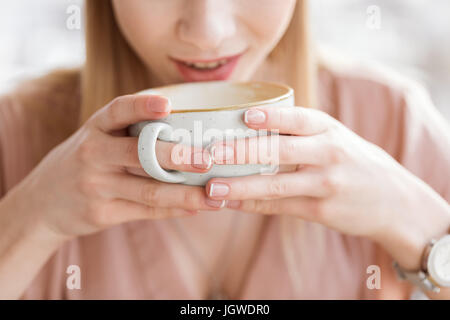 Vue rapprochée de la femme de boire du café à partir de la grande tasse Banque D'Images