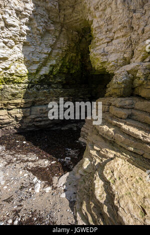 Grotte dans les falaises de craie à Selwicks bay, North Yorkshire, Angleterre. Banque D'Images