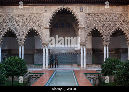 Les touristes visitent le Patio de las Apartment Doncellas (Cour de la Jeunes Filles) dans le Palacio Mudéjar mudéjar (Palace) à partir du 14e siècle dans l'Alcázar de Séville à Séville, Andalousie, espagne. Banque D'Images