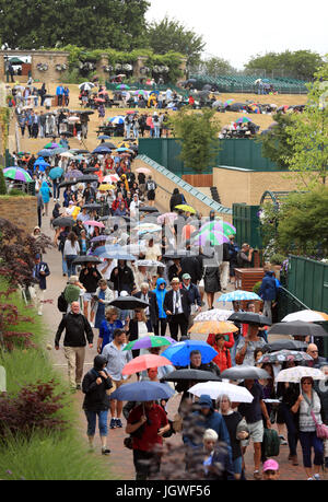 Les spectateurs à l'abri sous les parasols en pluie correspond au jour 8 des championnats de Wimbledon à l'All England Lawn Tennis et croquet Club, Wimbledon. Banque D'Images