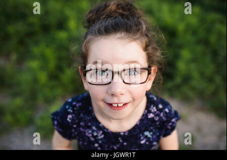 Portrait of cute girl wearing Eye glasses looking up at camera Banque D'Images