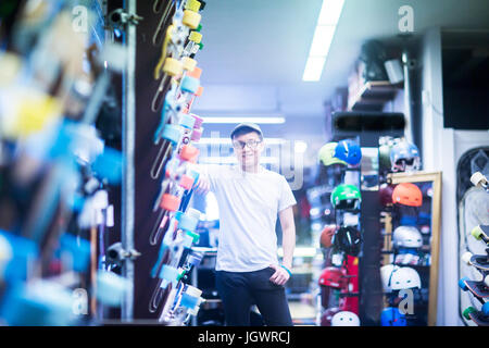 Portrait de jeune homme en skateboard shop sales assistant Banque D'Images