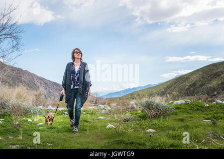 Young woman walking dog dans le paysage de la vallée Banque D'Images