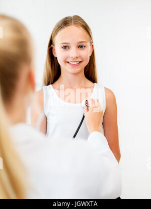 Doctor with stethoscope and girl at hospital Banque D'Images