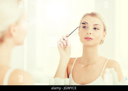 Woman brushing eyebrow avec brosse à bains Banque D'Images