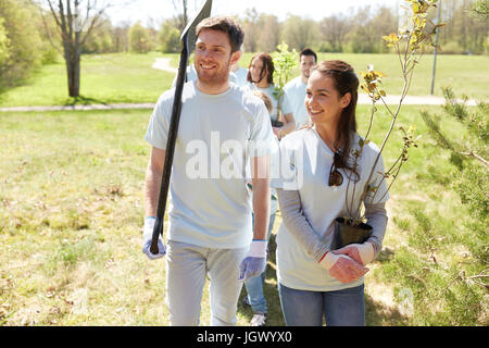 Groupe de bénévoles avec des arbres et rake in park Banque D'Images