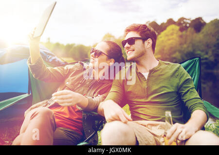 Couple heureux avec tablet pc at tente de camping Banque D'Images