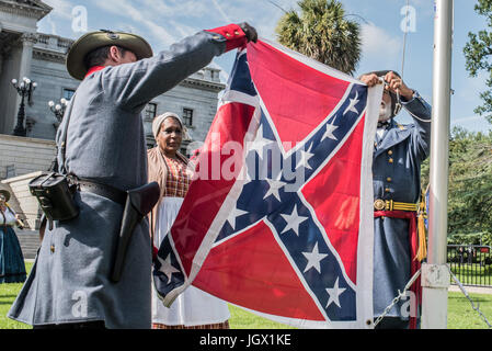 La Colombie, en Caroline du Sud, USA. 11Th Aug 2017. Confédération noir célébrité Arlene partisan de Barnum, Stuart Florida regarde reenactor confédéré Braxton Spivey de Charleston, Caroline du Sud attache un drapeau confédéré à un mât portable pendant le lever du drapeau des Confédérés l'événement organisé par la Caroline du Sud parti sécessionniste en signe de protestation contre le deuxième anniversaire de la bataille du drapeau confédéré dépose de la South Carolina State House motif en 2015. Credit : Crush Rush/Alamy Live News Banque D'Images