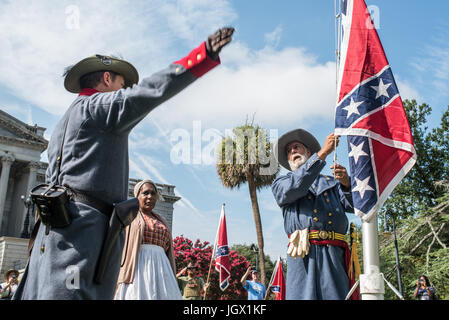 La Colombie, en Caroline du Sud, USA. 11Th Aug 2017. Reenactor confédéré Braxton Spivey de Charleston, Caroline du Sud est rejoint par un de ses collègues reenactor, et celebrity black Confederate Arlene Barnum de Stuart, New York comme il soulève un drapeau confédéré un mât portable pendant le lever du drapeau des Confédérés événement organisé par la Caroline du Sud parti sécessionniste en signe de protestation contre le deuxième anniversaire de la bataille du drapeau confédéré dépose de la South Carolina State House motif en 2015. Credit : Crush Rush/Alamy Live News Banque D'Images