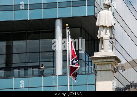 La Colombie, en Caroline du Sud, USA. 11Th Aug 2017. Une femme regarde depuis le balcon de la CVMNB bâtiment en face de la rue de la South Carolina State House au cours de la levée du drapeau des Confédérés événement organisé par la Caroline du Sud parti sécessionniste en signe de protestation contre le deuxième anniversaire de la bataille du drapeau confédéré dépose de la South Carolina State House motif en 2015. Credit : Crush Rush/Alamy Live News Banque D'Images