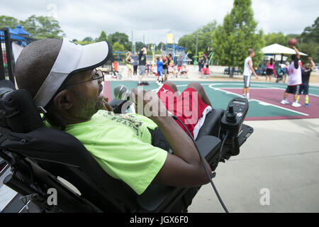 Dalton, GA, USA. 1er juillet 2017. Lance Stephens bénévoles en tant qu'annonceur pour un tournoi de basket-ball des jeunes de la communauté à Dalton.lance, aujourd'hui 48, vit avec la famille Curtis en raison de l'appui financier de sa renonciation Medicaid. Il a la paralysie cérébrale et précédente vivaient dans des foyers de groupe et de vie partagée. Crédit : Robin Rayne Nelson/ZUMA/Alamy Fil Live News Banque D'Images