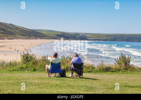 17 Juin 2017 : Woolacombe, North Devon, England, UK - couple assis sur la plage car les gens profiter du soleil sur l'une des journées les plus chaudes de l'y Banque D'Images