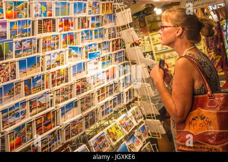 Un touriste se penche sur les cartes postales sur marché de nuit de Hua Hin, Thaïlande Banque D'Images